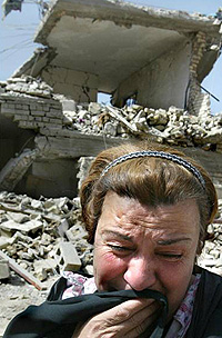 Colour Photograph :  'Woman Weeping in Baghdad' 2003.  War is not a long-distance game involving toy soldiers - human beings are killed and maimed, and the environment is destroyed !